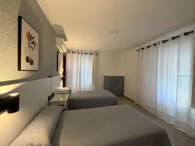 a hotel room with two beds and a window at Hostal Bahía in Cádiz
