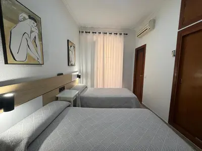 a hotel room with two beds and a window at Hostal Bahía in Cádiz