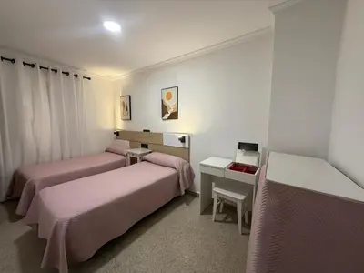 a hotel room with two beds and a desk at Hostal Bahía in Cádiz