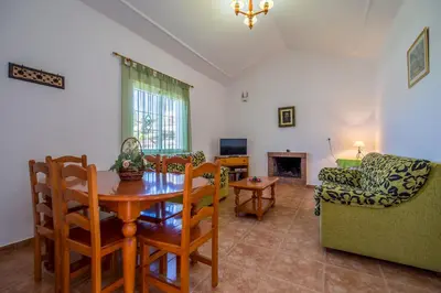 a living room with a table and chairs and a couch at Chalet Pedro III in Conil de la Frontera