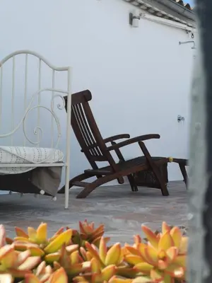 a rocking chair and a bench on a patio at TRIPERIA 25 in Medina Sidonia