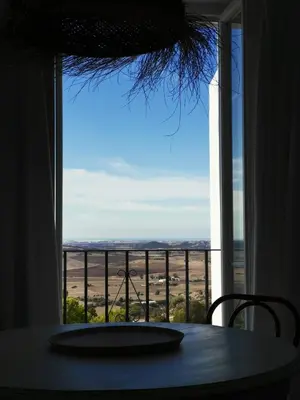 a table with a view of a field from a window at TRIPERIA 25 in Medina Sidonia