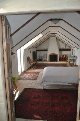 a bedroom with a white bed in an attic at Casa-Palacio La Casa Empeño en Centro Histórico in Arcos de la Frontera