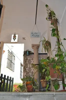 a room with potted plants and a column and a clock at Casa-Palacio La Casa Empeño en Centro Histórico in Arcos de la Frontera