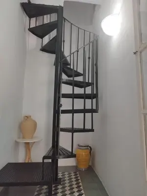 a black spiral staircase in a room with a floor at Casa-Palacio La Casa Empeño en Centro Histórico in Arcos de la Frontera