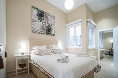 a bedroom with a large bed with white sheets at Apartamento Relax in Cadiz in Cádiz