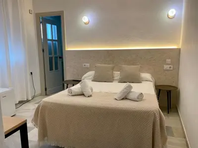 two white chairs and a table in a room at BOHEMIA SANLUCAR in Sanlúcar de Barrameda