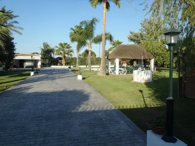 a brick walkway with a gazebo and palm trees at ABULAGAR in Rota