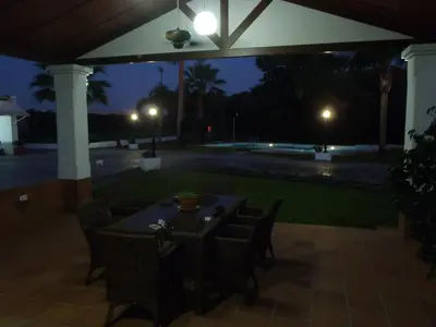 a table and chairs on a patio at night at ABULAGAR in Rota