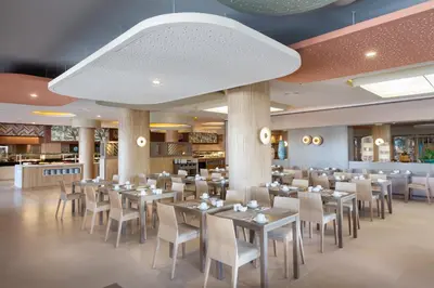 a dining room with tables and chairs in a restaurant at Hotel Riu Chiclana - All Inclusive in Chiclana de la Frontera