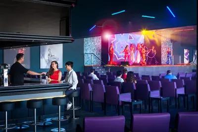 a group of people sitting at a bar in a theatre at Hotel Riu Chiclana - All Inclusive in Chiclana de la Frontera
