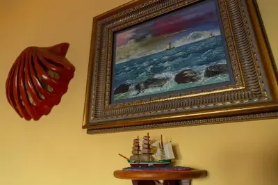 a picture of a painting of a ship on a wall at La casa del mar by Gades Gestión in Cádiz