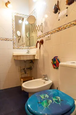 a bathroom with a toilet and a sink and a mirror at La casa del mar by Gades Gestión in Cádiz