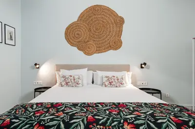 a bedroom with a large white bed with pillows at Art Suites by Casa de Indias in El Puerto de Santa María