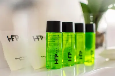 three green bottles of hair products sitting on a counter at Hotel de Francia y París in Cádiz