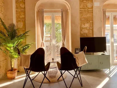 a living room with two chairs and a television at Feel the Sherry experience2 by Musgo in Jerez de la Frontera