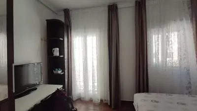 a living room with a tv and a window with curtains at Dormir en Cádiz in Cádiz