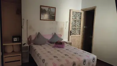 a bedroom with a bed with a pink and white comforter at Dormir en Cádiz in Cádiz