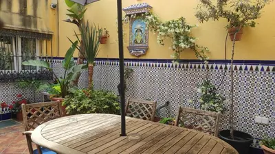 a wooden table with two chairs and a clock on the wall at Dormir en Cádiz in Cádiz