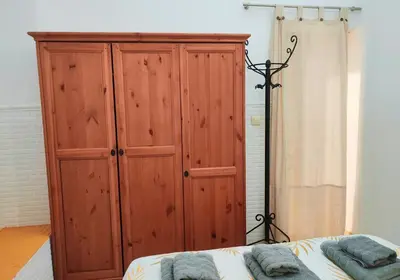 a bedroom with a large wooden cabinet next to a bed at Twins' Home Chancillería, Jerez Centro, Cádiz, wifi in Jerez de la Frontera