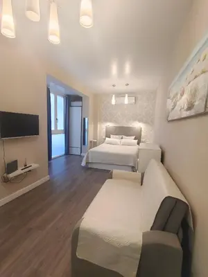 a bedroom with two beds and a couch and a tv at La Caleta - La Viña in Cádiz