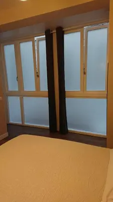 a bedroom with glass windows and a bed at La Caleta - La Viña in Cádiz