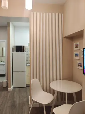 a room with a table and chairs and a refrigerator at La Caleta - La Viña in Cádiz