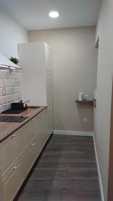 a kitchen with white cabinets and a counter top at La Caleta - La Viña in Cádiz