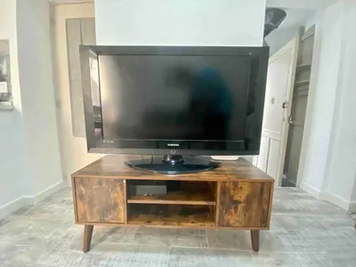 a flat screen tv sitting on top of a wooden entertainment center at Anticuario en el Teatro Falla in Cádiz