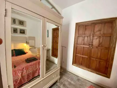 a bedroom with a bed and a large mirror at Anticuario en el Teatro Falla in Cádiz