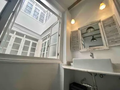 a bathroom with a sink and a large window at Anticuario en el Teatro Falla in Cádiz