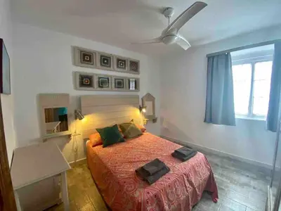 a bedroom with a bed and a ceiling fan at Anticuario en el Teatro Falla in Cádiz