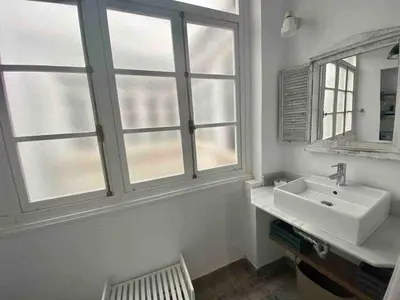 a bathroom with a sink and two windows at Anticuario en el Teatro Falla in Cádiz