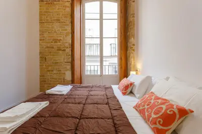 a bedroom with a large bed with a window at Casa Del COLECCIONISTA by Cadiz4Rentals in Cádiz