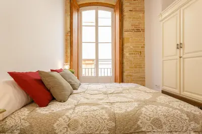 a bedroom with a large bed and a window at Casa Del COLECCIONISTA by Cadiz4Rentals in Cádiz