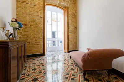 a room with a bed and a chair and a window at Casa Del COLECCIONISTA by Cadiz4Rentals in Cádiz