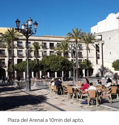 a group of people sitting at tables in a courtyard at APARTAMENTO Centro ciudad in Jerez de la Frontera