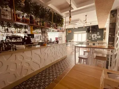 a kitchen with a bar with a counter and chairs at NOVO Apartahotel & Restaurante in Las Cabezas de San Juan