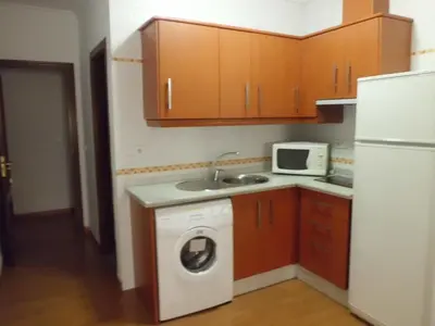 a kitchen with a washing machine and a microwave at NOVO Apartahotel & Restaurante in Las Cabezas de San Juan