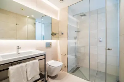 a bathroom with a shower and a toilet and a sink at Dormos Hotel in Cádiz