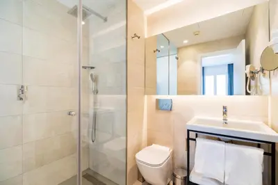 a bathroom with a shower and a toilet and a sink at Dormos Hotel in Cádiz
