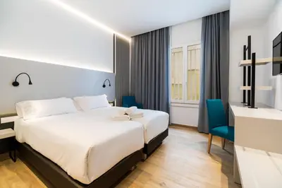 a hotel room with a bed and a desk at Dormos Hotel in Cádiz