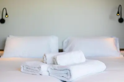 a pile of towels sitting on top of a bed at Dormos Hotel in Cádiz