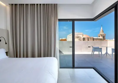 a bedroom with a bed and a view of the city at Dormos Hotel in Cádiz