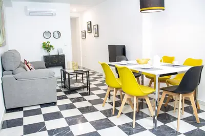 a dining room with a table and yellow chairs at Apartamento Argantonio by Cadiz Time in Cádiz