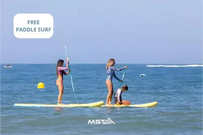three girls are standing on surfboards in the ocean at Apartamento Argantonio by Cadiz Time in Cádiz