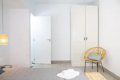 a bedroom with a bed and a chair at Apartamento Argantonio by Cadiz Time in Cádiz