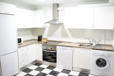 a white kitchen with a sink and a dishwasher at Apartamento Argantonio by Cadiz Time in Cádiz