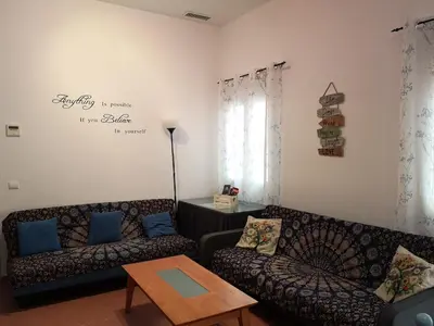 a living room with two couches and a table at Corazón del Puerto de Santa María in El Puerto de Santa María