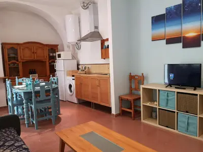 a living room with a table and a kitchen with a dining room at Corazón del Puerto de Santa María in El Puerto de Santa María